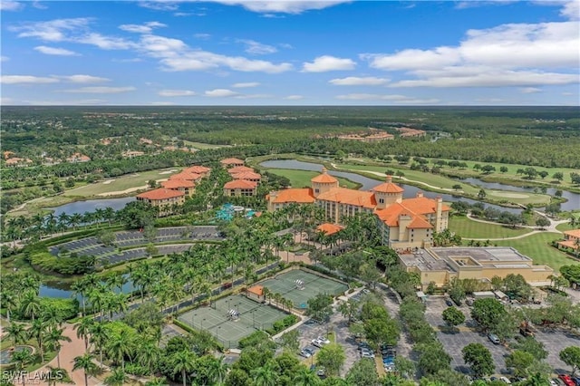 aerial view with view of golf course, a water view, and a wooded view