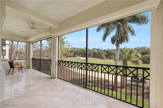 sunroom with beamed ceiling and a ceiling fan