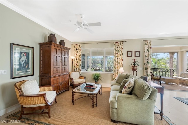 living area featuring a ceiling fan, a wealth of natural light, crown molding, and baseboards