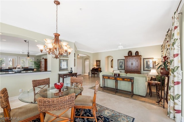 dining space with ornamental molding, arched walkways, and a ceiling fan