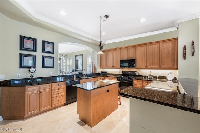 kitchen with ornamental molding, dark stone countertops, a center island, black appliances, and a sink