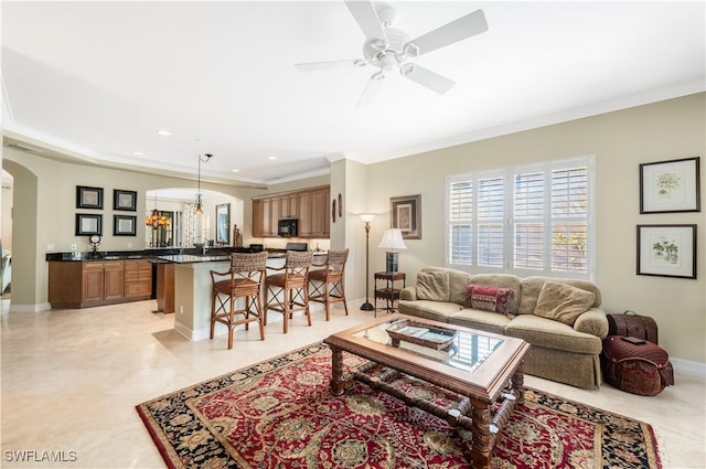 living area with baseboards, arched walkways, ceiling fan, crown molding, and recessed lighting