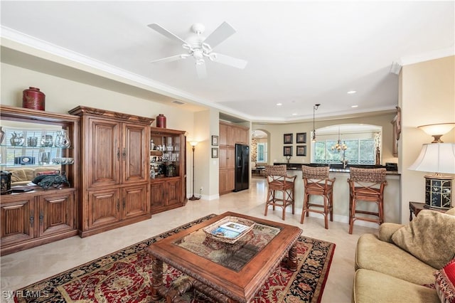 living area with baseboards, a ceiling fan, crown molding, and recessed lighting