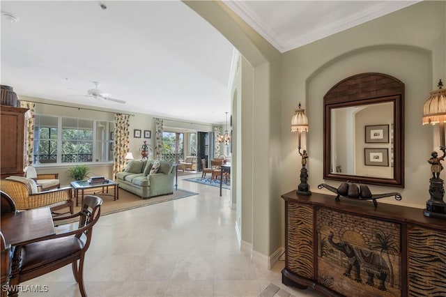 hall featuring an inviting chandelier, baseboards, and crown molding