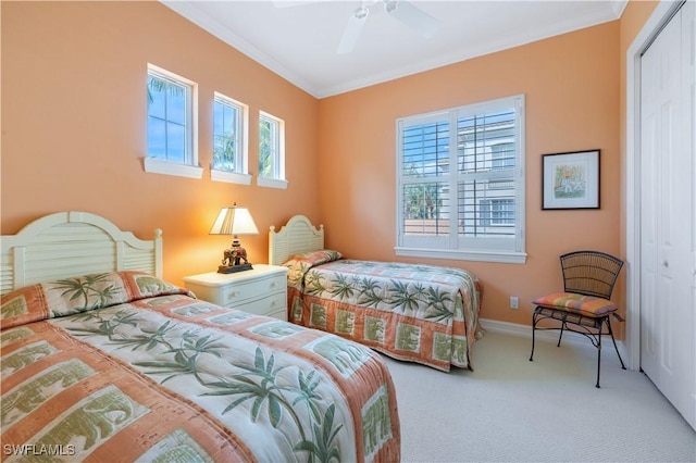 carpeted bedroom with ornamental molding, a closet, a ceiling fan, and baseboards