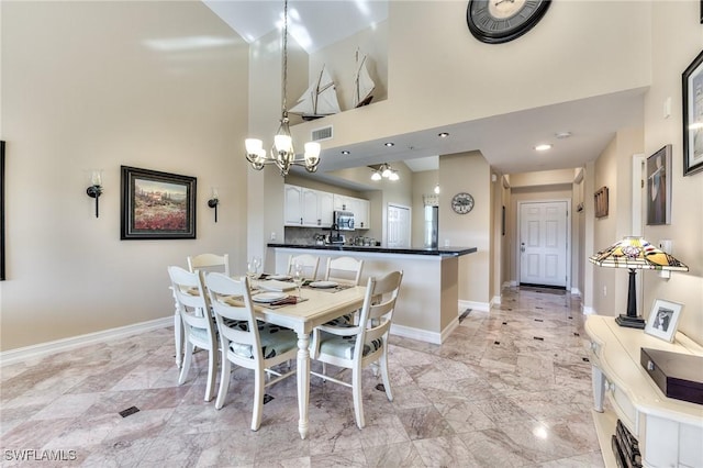 dining space with a high ceiling and an inviting chandelier