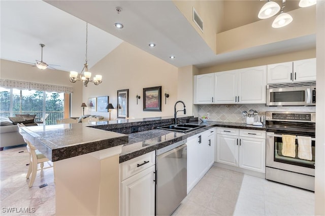 kitchen with kitchen peninsula, white cabinetry, sink, and stainless steel appliances