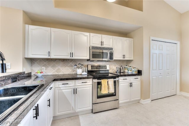 kitchen with white cabinets, light tile patterned floors, appliances with stainless steel finishes, and tasteful backsplash