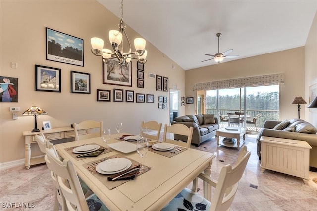 dining space with ceiling fan with notable chandelier and high vaulted ceiling