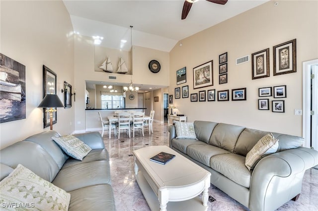 living room featuring ceiling fan with notable chandelier and vaulted ceiling