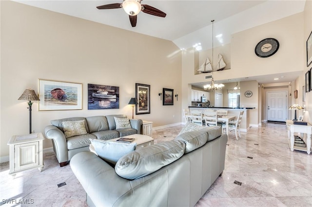 living room featuring ceiling fan with notable chandelier and high vaulted ceiling