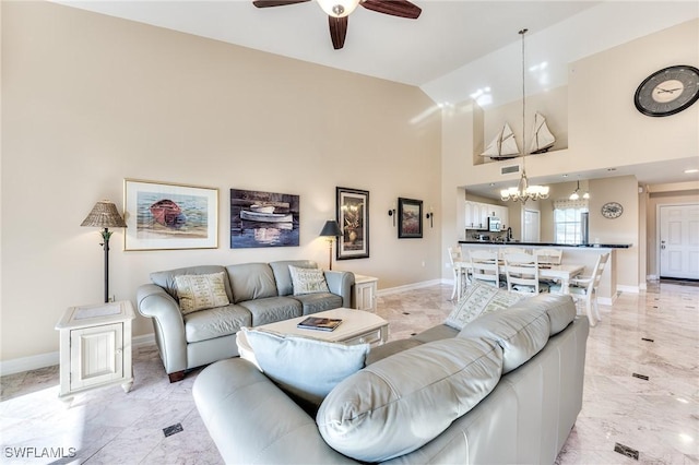 living room featuring high vaulted ceiling and ceiling fan with notable chandelier