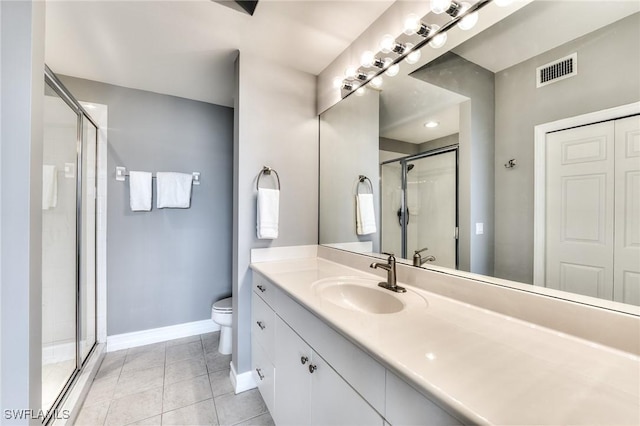 bathroom featuring tile patterned flooring, vanity, toilet, and walk in shower