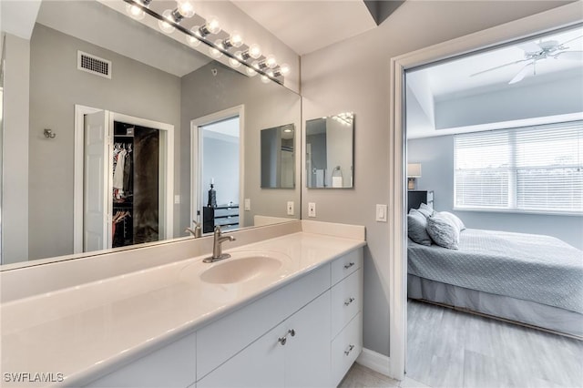 bathroom featuring wood-type flooring, vanity, and ceiling fan