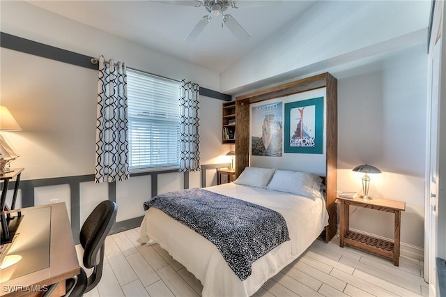 bedroom with ceiling fan, light wood-type flooring, and lofted ceiling