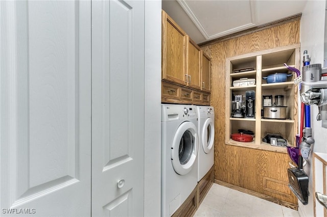 clothes washing area featuring separate washer and dryer, wooden walls, cabinets, and ornamental molding