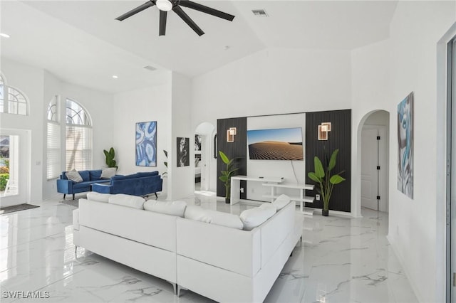 living room featuring a towering ceiling and ceiling fan