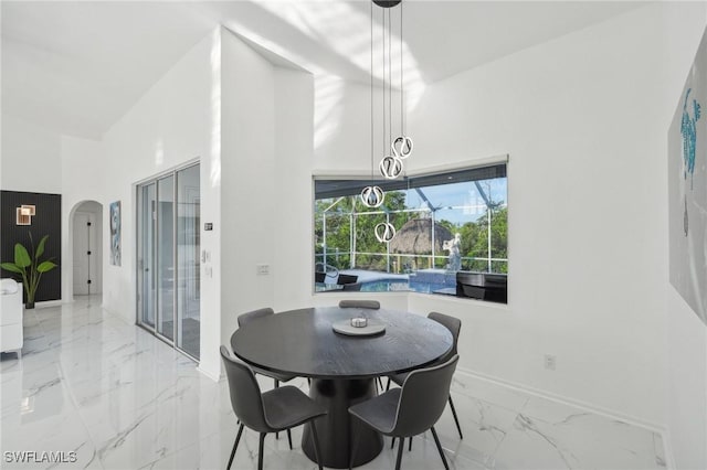 dining area with a towering ceiling