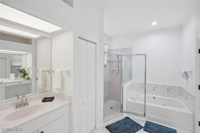 bathroom with vanity and shower with separate bathtub