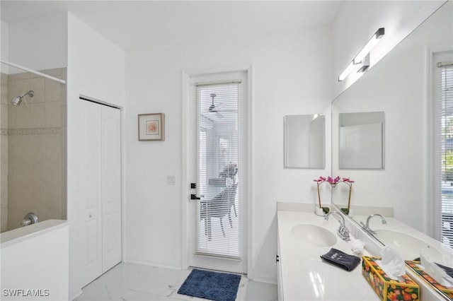 bathroom with a tile shower and vanity