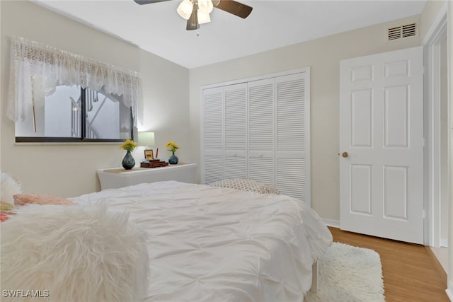 bedroom with ceiling fan, light hardwood / wood-style flooring, and a closet