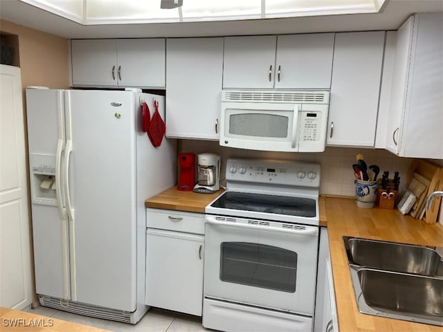 kitchen with sink, wood counters, white appliances, decorative backsplash, and light tile patterned flooring