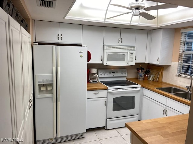 kitchen featuring wood counters, white appliances, ceiling fan, sink, and light tile patterned floors