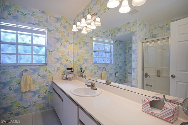 bathroom featuring a chandelier, tile patterned flooring, vanity, and a shower with shower door