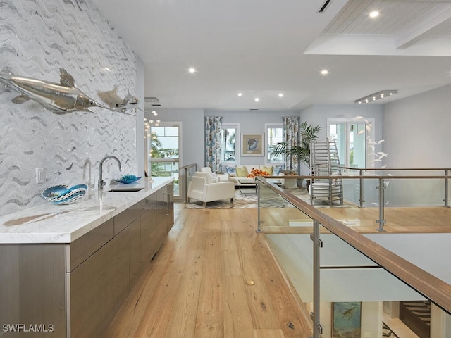 kitchen featuring tasteful backsplash, sink, a wealth of natural light, and light wood-type flooring