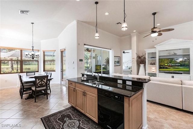 kitchen with ceiling fan with notable chandelier, sink, dark stone countertops, black dishwasher, and an island with sink