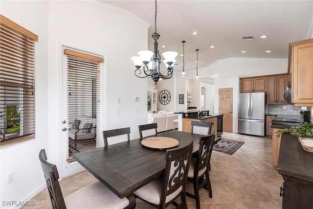 dining space with crown molding, sink, light tile patterned floors, a notable chandelier, and lofted ceiling