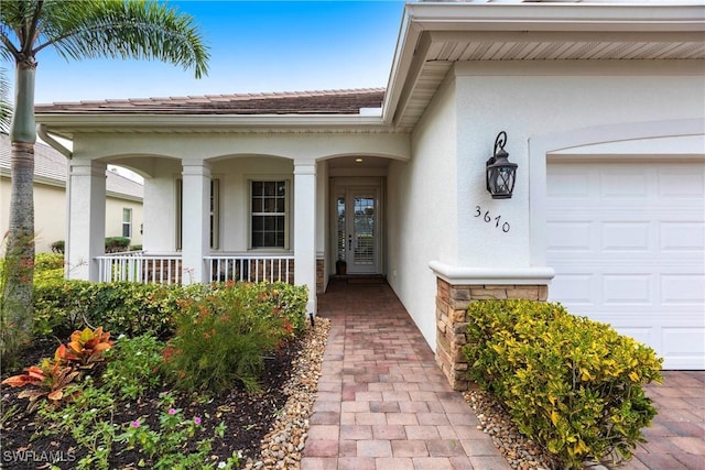 property entrance featuring covered porch and a garage