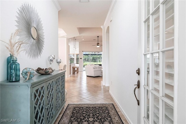 entrance foyer featuring ceiling fan, light tile patterned floors, and ornamental molding