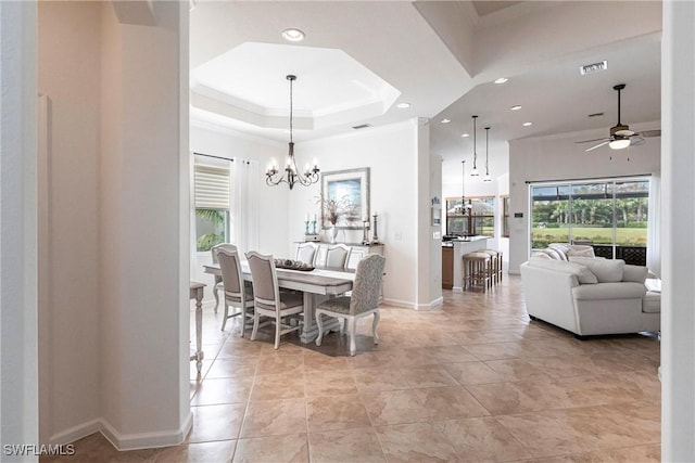 dining area featuring ceiling fan with notable chandelier, a raised ceiling, plenty of natural light, and light tile patterned floors