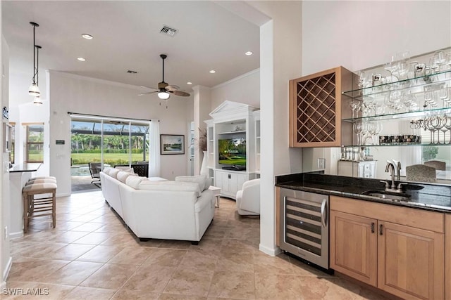 bar featuring crown molding, sink, decorative light fixtures, dark stone countertops, and wine cooler