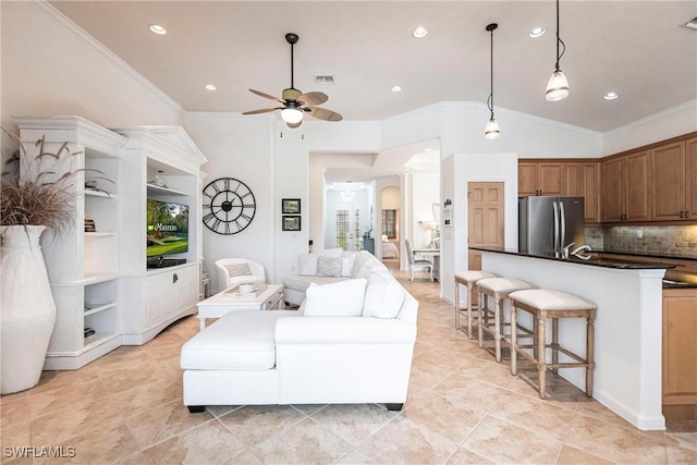 living room with ceiling fan, vaulted ceiling, and ornamental molding