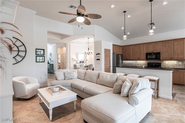 tiled living room featuring vaulted ceiling, ceiling fan with notable chandelier, and ornamental molding