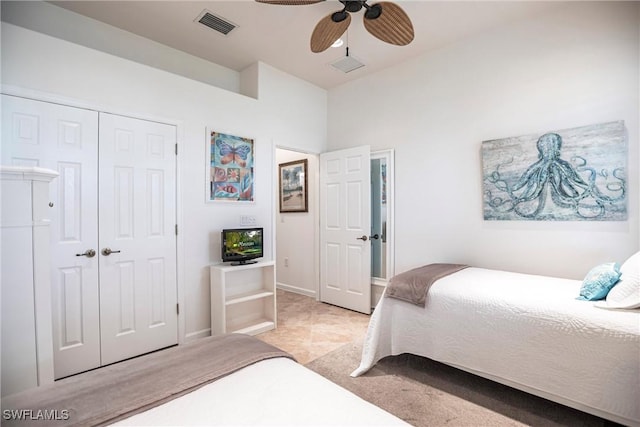 bedroom featuring ceiling fan, light tile patterned flooring, and a closet