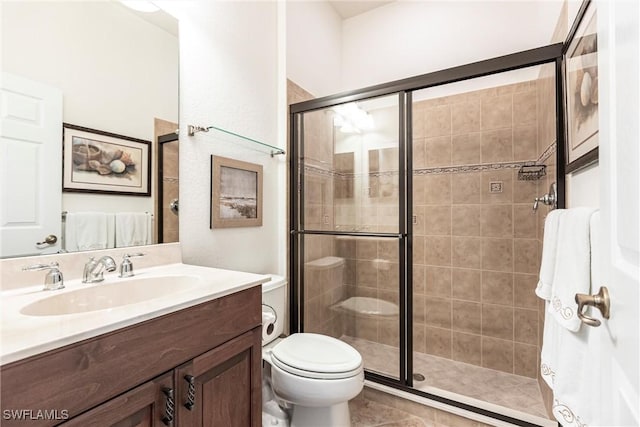 bathroom with vanity, a shower with shower door, and toilet