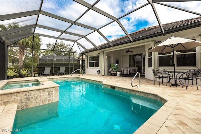 view of swimming pool featuring an in ground hot tub, a patio, glass enclosure, and ceiling fan