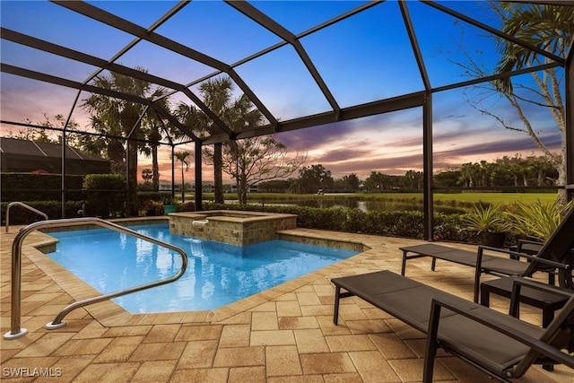 pool at dusk with glass enclosure, an in ground hot tub, and a patio