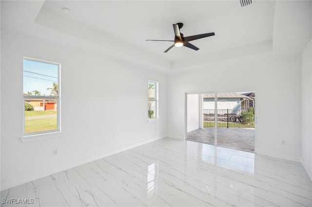 unfurnished room featuring a tray ceiling and ceiling fan