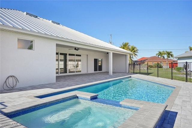 view of swimming pool featuring ceiling fan, a patio, and an in ground hot tub