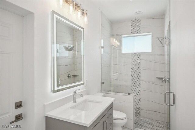 bathroom with vanity, toilet, and a shower with shower door