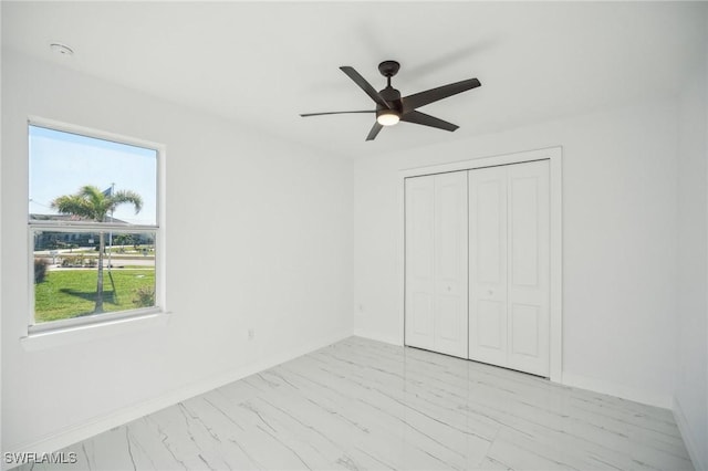 unfurnished bedroom featuring ceiling fan and a closet