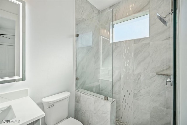 bathroom with a tile shower, vanity, and toilet