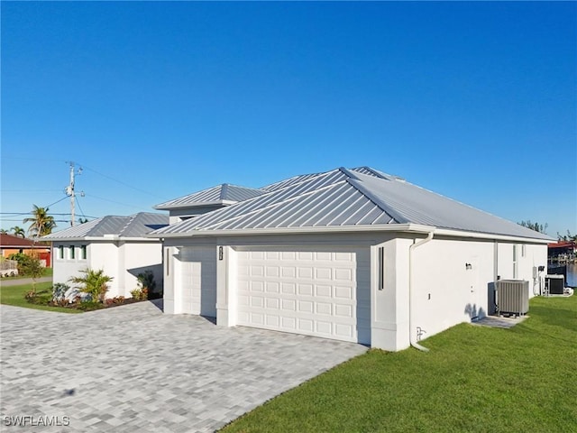 view of home's exterior with a lawn, cooling unit, and a garage