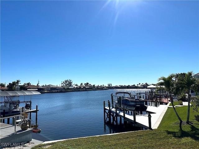 view of dock with a water view and a lawn