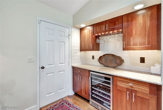 bar featuring decorative backsplash, light stone countertops, wine cooler, and vaulted ceiling