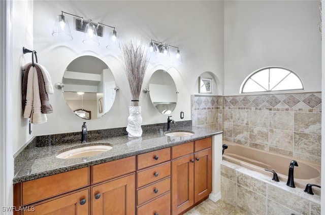 bathroom with vanity and tiled bath